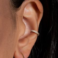 a close up view of a woman's ear with a diamond ring on it