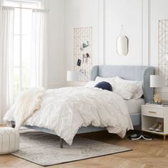 a bedroom with white walls and wooden floors