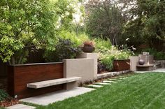 a garden with grass, trees and benches