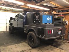 the truck is parked in the garage with its hood up and it's flatbed