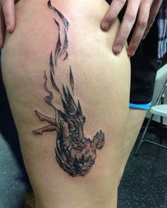 a woman's thigh with a tattoo design on the leg and an image of a demon