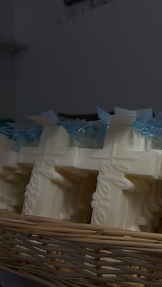 four soap bars in a wicker basket with blue bows on them, sitting next to each other