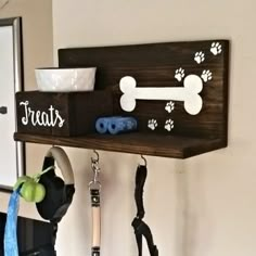 there is a dog bone and paw sign on the wall next to some leashes