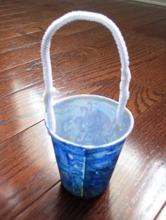 a blue and white basket sitting on top of a wooden floor