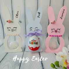 three wooden easter bunnies with bunny ears on them and the words happy easter painted on them