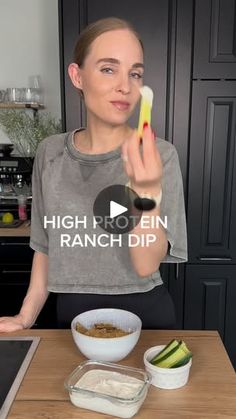 a woman holding up a banana in front of her face while standing at a kitchen counter