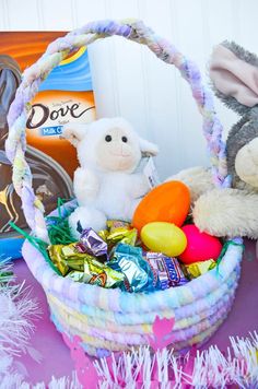 two stuffed animals sitting next to a basket filled with candy