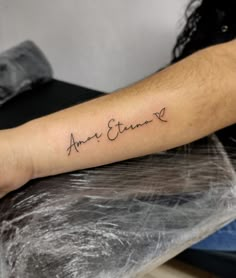 a person with a tattoo on their arm that says, ann eterne written in cursive font