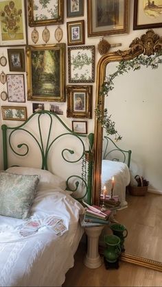 a bedroom with pictures on the wall and a bed in front of a large mirror