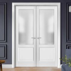 two white double doors in a room with blue walls and wood flooring on the side