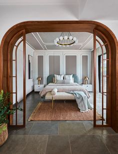 a bedroom with an arched doorway leading to another room and a bed in the corner