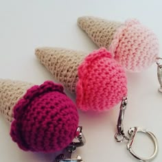 three crocheted ice cream cones with keychains on white surface next to each other