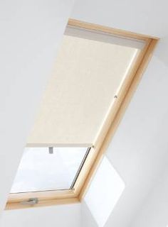 a white room with a skylight in the corner and a window on the far wall