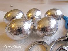 several shiny silver balls sitting on top of a white cloth next to scissors and pliers