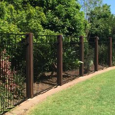 a black iron fence in the middle of a grassy area