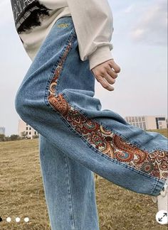 a person standing in the grass with their feet on his pants and one leg up