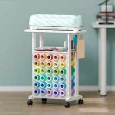 a toy crib with lots of different colored paper rolls on it's wheels