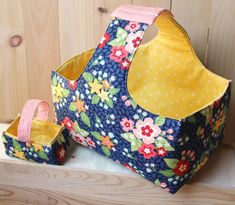 two bags sitting next to each other on top of a wooden shelf with polka dots and flowers