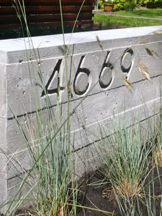 a cement block with the number 468 written on it and grass growing in front