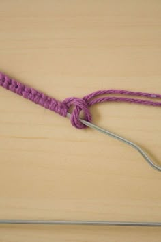 a pair of knitting needles are hooked up to the end of a piece of yarn