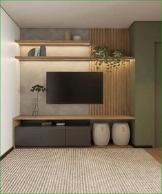 a living room with a large tv on the wall and two vases in front of it