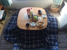 a table with food and drinks on it in the middle of a living room area