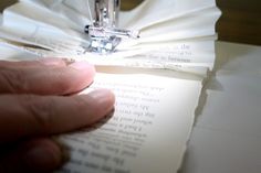 a person is cutting out some paper with a sewing machine