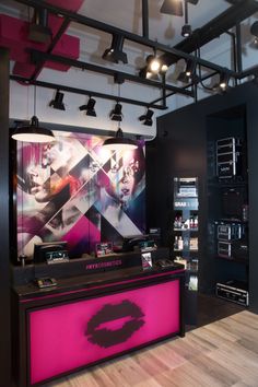 the front desk is decorated with pink and black accents, along with two large posters