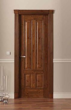 a wooden door in an empty room with two glasses on the floor next to it