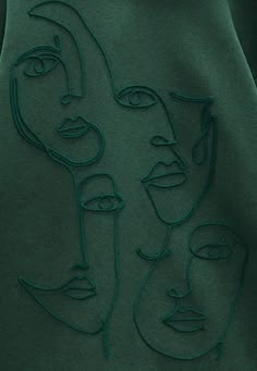 a green sweatshirt with faces drawn on it