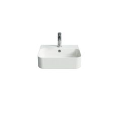 a white bathroom sink sitting under a faucet next to a wall mounted soap dispenser