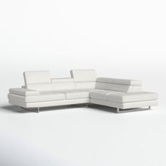 a white leather sectional sofa sitting on top of a white floor next to a chair