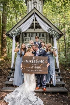 a group of people standing in front of a gazebo holding a sign that says welcome