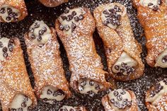 several pastries covered in powdered sugar and chocolate sprinkled on top of each other