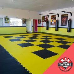 a yellow and black checkered floor with boxing gloves hanging on the wall next to it