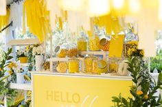 a yellow and white dessert stand with lemons, candies, and other sweets