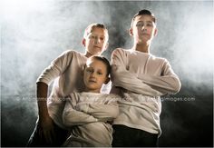 three people are posing for a photo in front of a foggy background with their arms around each other