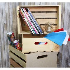 a wooden box with books, magazines and an umbrella in it sitting on top of a table