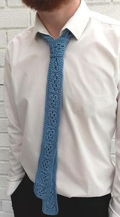 a bearded man wearing a white shirt and blue crochet tie