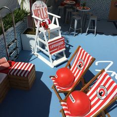 red and white striped lawn chairs sitting on top of a blue floor next to a lifeguard chair