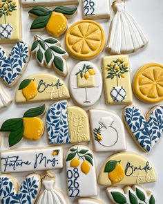 decorated cookies are arranged in the shape of flowers, lemons, and bride's dresses