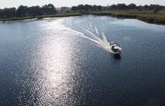 a boat is traveling down the river with its wake behind it's back end