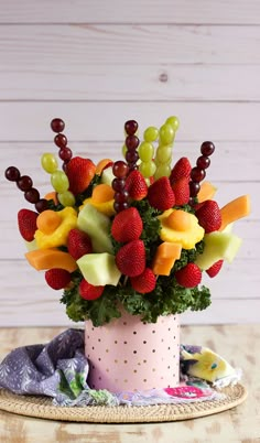 a vase filled with lots of fruit on top of a table