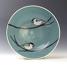 two small birds perched on branches in a blue bowl