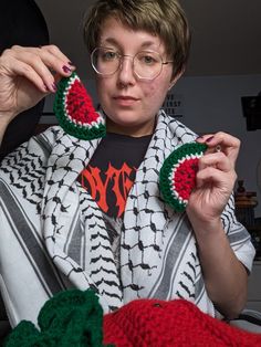 a woman is holding up two pieces of crochet