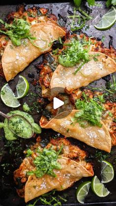 some food is laying out on a tray with limes and cilantro wedges