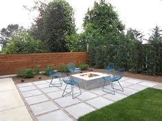 an outdoor fire pit surrounded by blue chairs