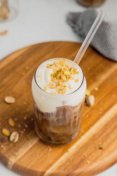 a dessert in a glass on top of a wooden cutting board