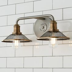 two light fixtures mounted on a white brick wall