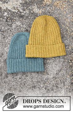 two knitted hats sitting on top of a cement surface with the words drops design below it